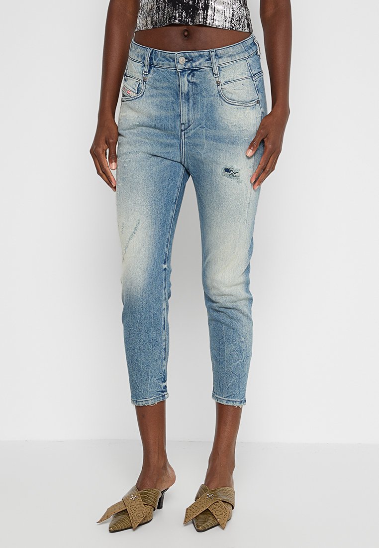 Hellblaue Denim-Jeans mit schmaler Passform, ausgefransten Details und verkürzter Länge. Verfügt über fünf Taschen und einen Knopfverschluss.
