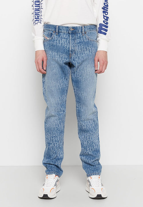 Helle blaue Jeans aus Denim mit einem strukturierten Muster, fünf Taschen, geradem Bein und subtiler Ausbleichung. Getragen mit weißen Turnschuhen und einem Langarmshirt.
