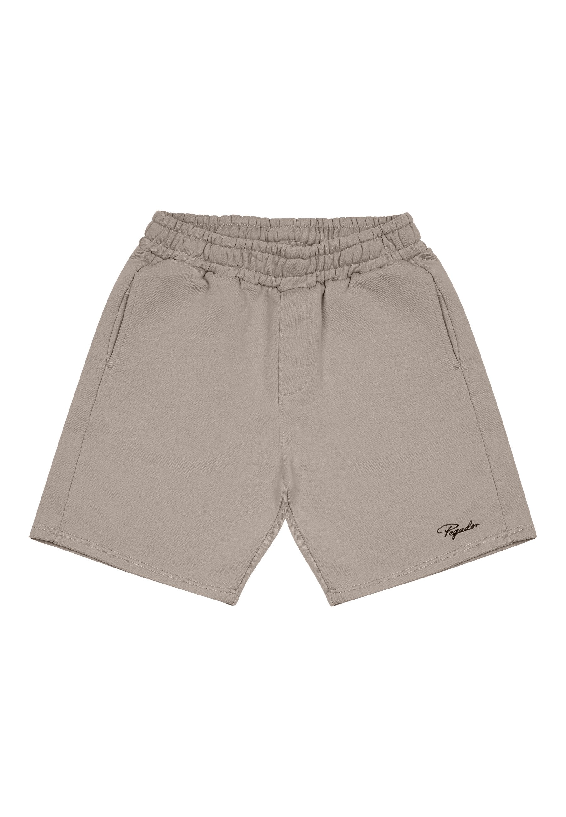 Beige Baumwollshorts mit elastischem Bund, seitlichen Taschen und einem einzelnen schwarzen gestickten Logo auf der linken unteren Seite.