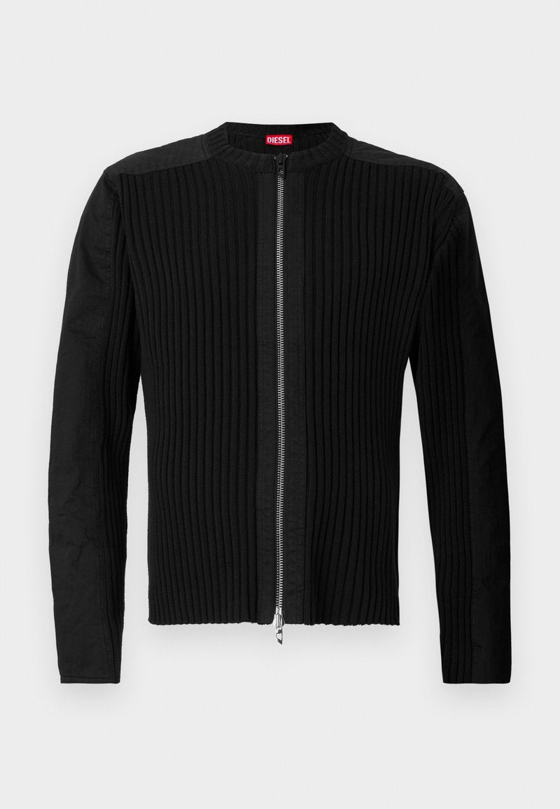 Schwarze Jacke mit Reißverschluss vorne, die eine vertikale gerippte Struktur und einen runden Ausschnitt aufweist. Weicher Stoff mit langen Ärmeln und einer taillierten Silhouette.