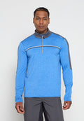 Mann trägt einen langärmligen blauen Sportpullover mit grauen Akzenten und einem Viertelreißverschluss am Kragen, kombiniert mit grauer Hose, steht vor einem weißen Hintergrund.