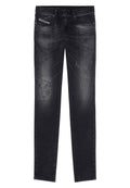 Schwarze Jeans aus Denim mit schmaler Passform, die mit abgenutzten Patches, leichter Ausbleichung und traditionellem Fünf-Taschen-Design sowie einem standardmäßigen Knopfverschluss versehen sind.