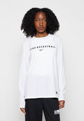 Frau mit lockigem Haar, die ein weißes langärmeliges Nike Basketball-Shirt und eine schwarze Hose vor einem schlichten hellen Hintergrund trägt.