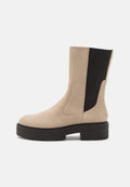 Beige Wildleder-Stiefelette mit schwarzen elastischen Seiteneinsätzen und einer klobigen schwarzen Plattformsohle. Verfügt über eine glatte Oberfläche und ein rundes Zehendesign.