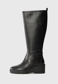 Schwarze Lederstiefel bis zum Knie mit Keilsohle, glatter Textur, nahtlosem Design und einem kleinen Ziehband oben für einfaches Anziehen.