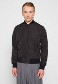 Schwarze Bomberjacke aus leichtem Material, mit einem Frontreißverschluss, gerippten Bündchen und seitlichen Taschen. Glatte Textur mit minimaler Detailgestaltung.