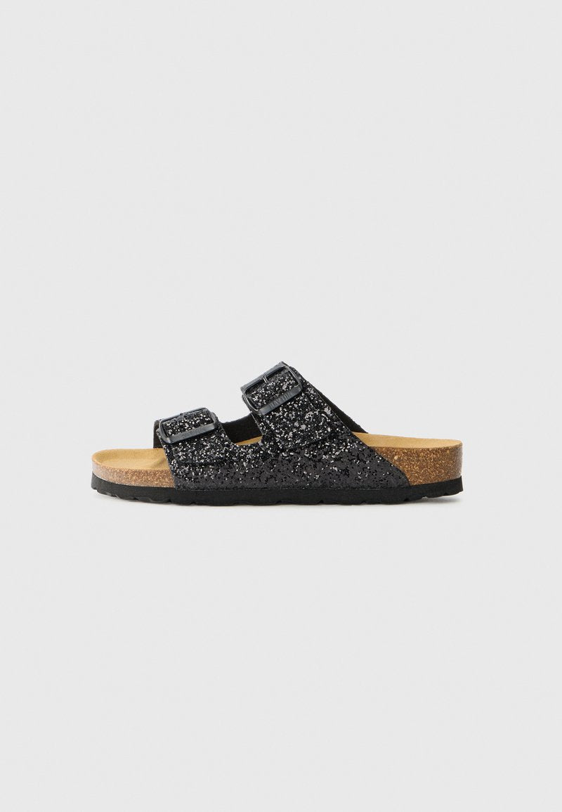 Schwarze Glitzer-Sandalen zum Hineinschlüpfen mit zwei verstellbaren Riemen, Korkfußbett und strukturierter schwarzer Gummisohle. Der funkelnde Glanz sorgt für ein optisches Highlight.