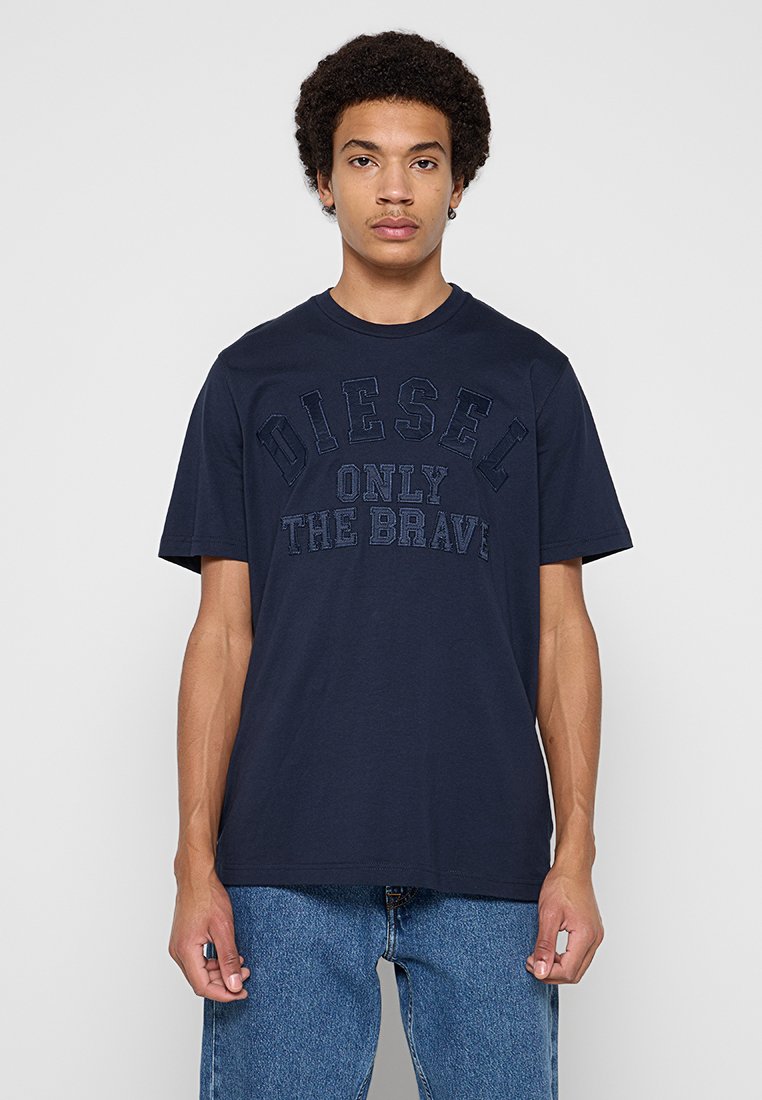 Marineblaues T-Shirt mit kurzen Ärmeln aus Baumwolle, mit erhabenem Schriftzug "DIESEL ONLY THE BRAVE" auf der Vorderseite. Legere Passform mit rundem Ausschnitt.