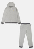 Grau-gestreiftes Loungewear-Set bestehend aus einem Kapuzenoberteil mit weißen Kordeln und passenden schmal zulaufenden Hosen mit dunkler grauen Bündchen. Strukturierter Stoff.