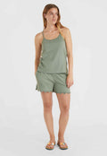 Olivgrünes Trägertop mit dünnen Trägern, kombiniert mit passenden Shorts mit gewählten Kanten. Das Model trägt farbige Flip-Flops.