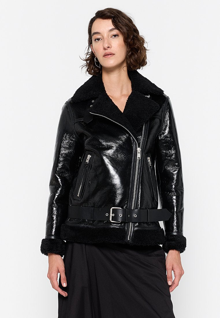 Schwarze Kunstlederjacke mit glänzender Oberfläche, Fellkragen, Reißverschlusstaschen und tailliertem Bund. Verfügt über eine weiche Textur und ein strukturiertes Design.