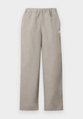 Beige gerade geschnittene Hose mit elastischem Bund und kleinem weißem Logo an der rechten Seitennaht.