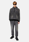 Grau Denim-Hoodie mit Kängurutasche, schwarzem geripptem Saum, passenden grauen Hosen und schwarzen strukturierten Sneakers. Silberne Hardware-Details.