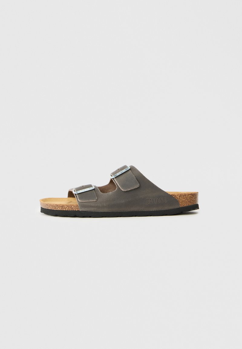 Graue Leder-Slidesandale mit zwei verstellbaren silbernen Schnallen, Korkfußbett und schwarzer Gummisohle. Minimalistisches Design mit glatter Textur.