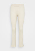 Rippige, cremefarbene Leggings mit einem enganliegenden Bund, weitem Saum am unteren Ende und einer weichen Stricktextur.