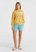 Gelbes Sweatshirt mit grafischem Druck, kombiniert mit hellblauen Shorts und weißen Schlüpfsandalen. Lässiger Schnitt und weicher Stoff.