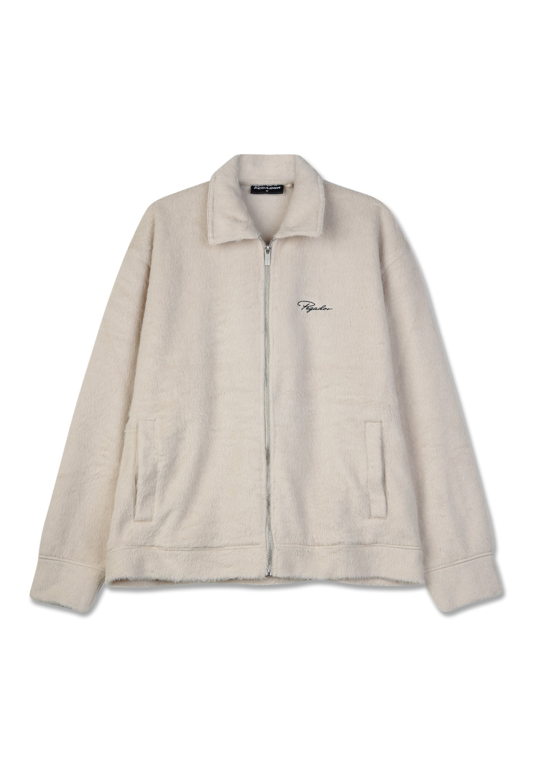 Fleece-Jacke in Hellbeige mit Reißverschluss vorne, Kragen, zwei Seitentaschen und gesticktem Logo auf der linken Brust. Weicher Stoff überall.