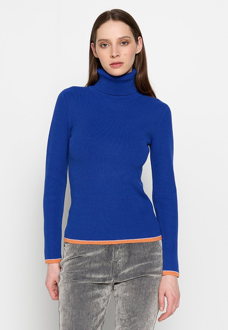 Blauer gerippter Rollkragenpullover mit langen Ärmeln, der einen orangen Akzent am Saum aufweist. Hergestellt aus einem glatten, strukturierten Strickmaterial.
