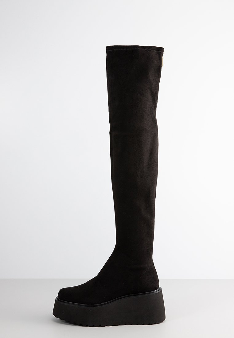 Schwarzer faux Suede Overknee-Stiefel mit Plattformsohle, ausgestattet mit einer abgerundeten Zehenpartie und glattem Textil, entworfen für eine enge Passform.