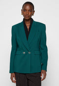 Teal, doppelt geknöpfter Blazer mit Schößchen, silbernen Knopfakzenten und Seitentaschen. Getragen über einem schwarzen Oberteil, kombiniert mit gestreiften Hosen.
