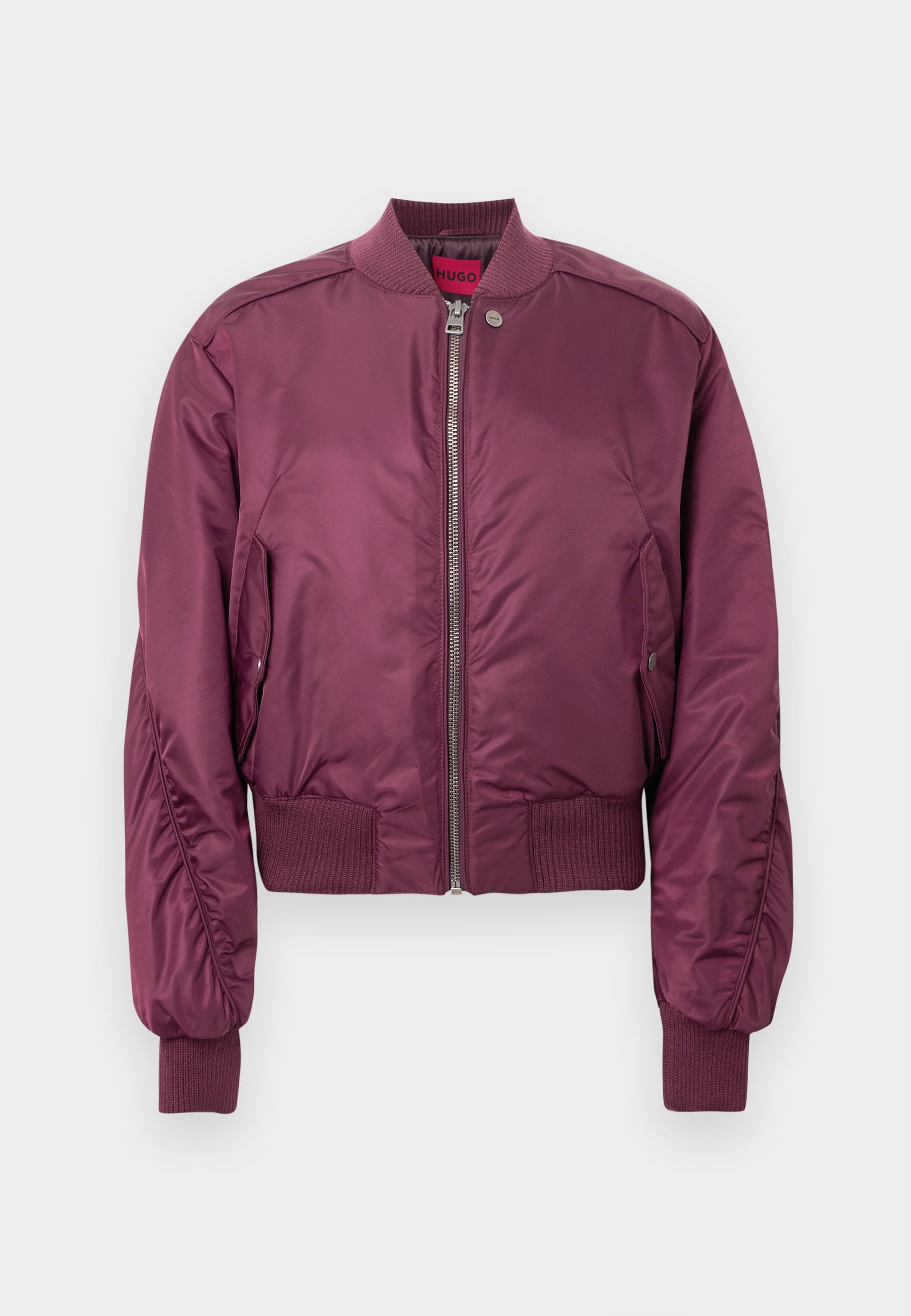 Bordeauxrote Bomberjacke mit glattem, glänzendem Finish, gerippten Bündchen und Saum. Mit Reißverschluss vorne und seitlichen Taschen. Leichtes Design.