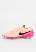 Nike-Fußballschuh mit strukturiertem apricotfarbenem Obermaterial, schwarzem Swoosh-Logo und einer Verlaufssohle in Pink. Ausgestattet mit Schnürsenkeln und transparenten Stollen.