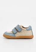 Beiger und blauer Ledersneaker für Kinder mit zwei verstellbaren Klettverschlüssen und einer flexiblen braunen Gummisohle.