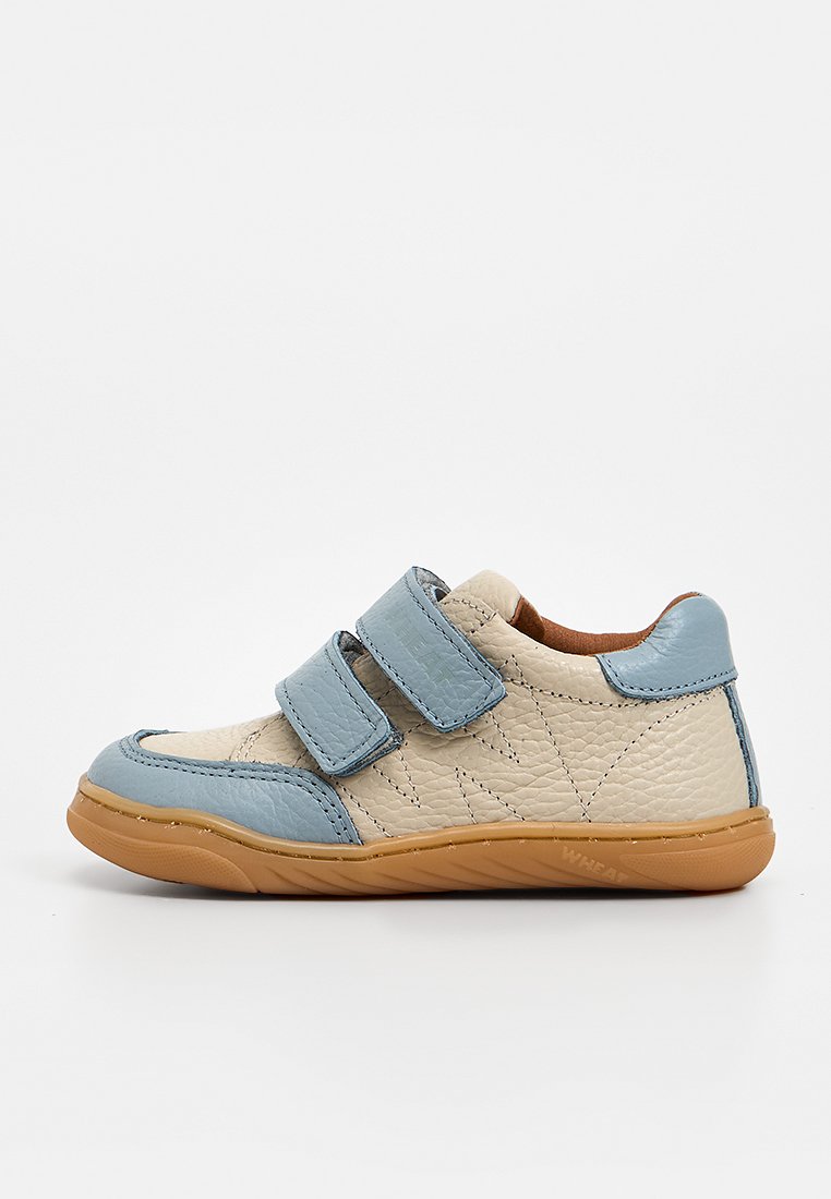 Beiger und blauer Ledersneaker für Kinder mit zwei verstellbaren Klettverschlüssen und einer flexiblen braunen Gummisohle.