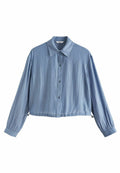 Himmelblaues, tailliertes Button-Up-Hemd aus strukturiertem Stoff, mit spitzen Kragen und langen Ärmeln mit engen Manschetten. Verfügt über eine Knopfleiste vorne.