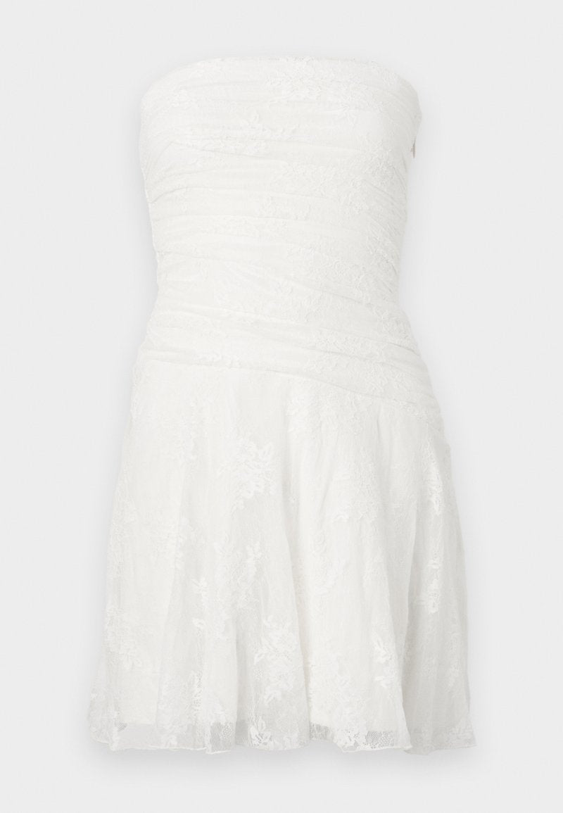 Weißes trägerloses Kleid mit gerafftem Oberteil, Spitzenverzierungen und ausgestelltem Rock. Hergestellt aus leichtem Stoff mit strukturierter Oberfläche.