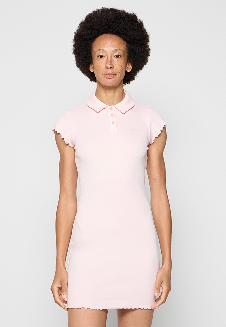 Polo-Kleid aus weichem rosa Baumwollstoff mit kurzen, gerafften Ärmeln, einem Kragen und einer Knopfleiste mit drei Knöpfen. Dezentes Logo-Detail auf der Brust.