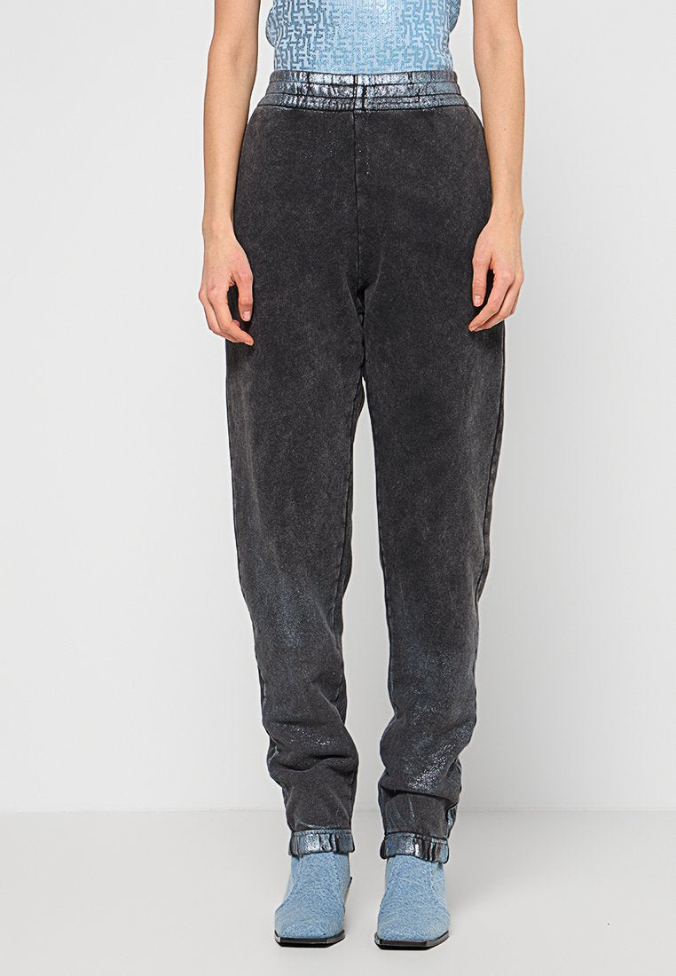 Schwarze Denim-Jogginghosen mit Acid-Wash-Finish, ausgestattet mit einem dehnbaren Bund und abgestuften Knöcheln, kombiniert mit blauen Schuhen.