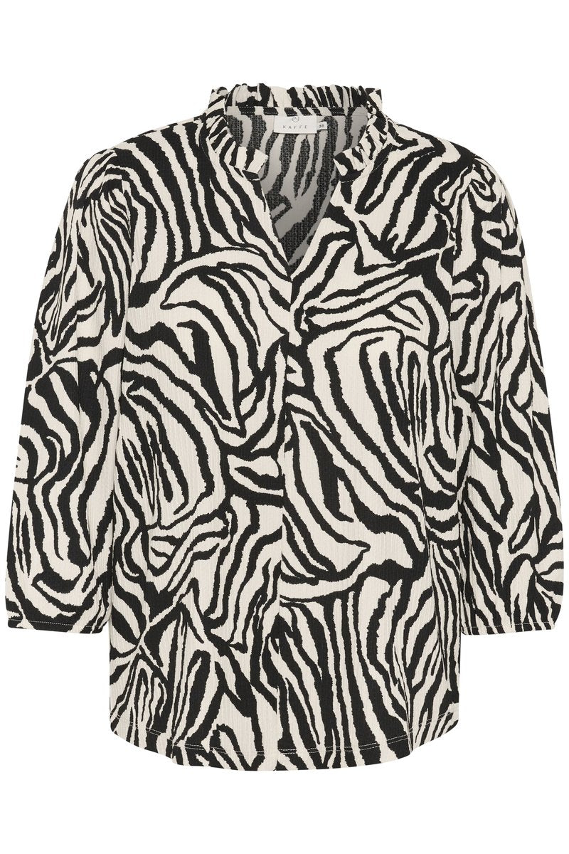 Schwarz-weiße Bluse mit Zebramuster. Verfügt über einen V-Ausschnitt, Dreiviertelärmel und einen strukturierten Stoff mit einem Rüschendetail am Kragen.