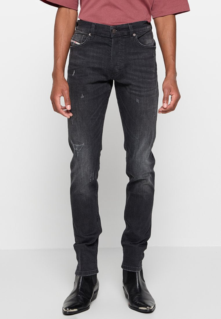 Schlanke Jeans aus dunkel gewaschenem Denim, mit verblichenen Bereichen und leichter Distressierung. Fünf-Taschen-Design mit einem Knopfverschluss vorne.