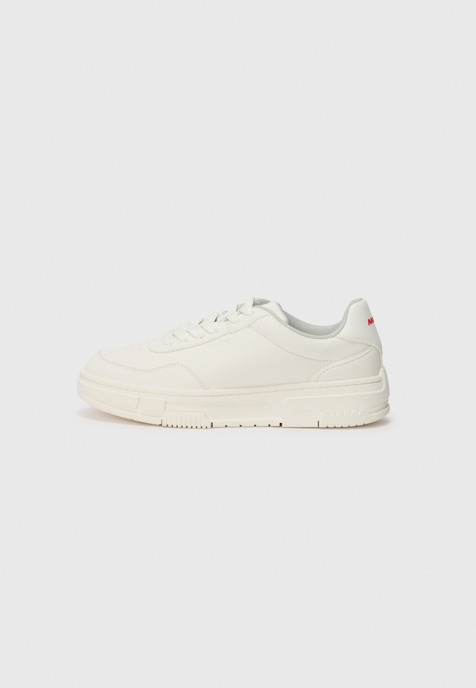Weißes Sneaker-Modell mit einer glatten Lederoberfläche, runder Zehenpartie, flachen Schnürsenkeln und einer strukturierten Gummisohle. Ein roter Akzent befindet sich an der Ferse.