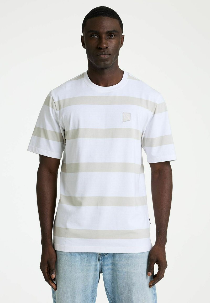 Kurzärmeliges T-Shirt mit Rundhalsausschnitt in Weiß mit beigen horizontalen Streifen. Verfügt über ein kleines Logo auf der linken Brust und einen lockeren Schnitt.