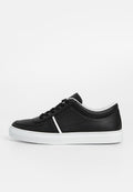 Schwarze Sneakers mit perforiertem Design, weißen Akzenten, Schnürverschluss und einer flachen, weißen Gummisohle. Glatte und strukturierte Materialien.