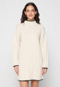 Strickkleid in Creme mit gerippter Textur, hohem Kragen und schwarzem Besatz an den Manschetten und dem Saum. Lockere Passform und lange Ärmel.