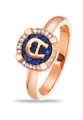 Rosenvergoldeter Ring mit einem blauen Stein im Mittelpunkt, der den auffälligen Buchstaben "C" zeigt, verziert mit klaren Steinen am Rand.