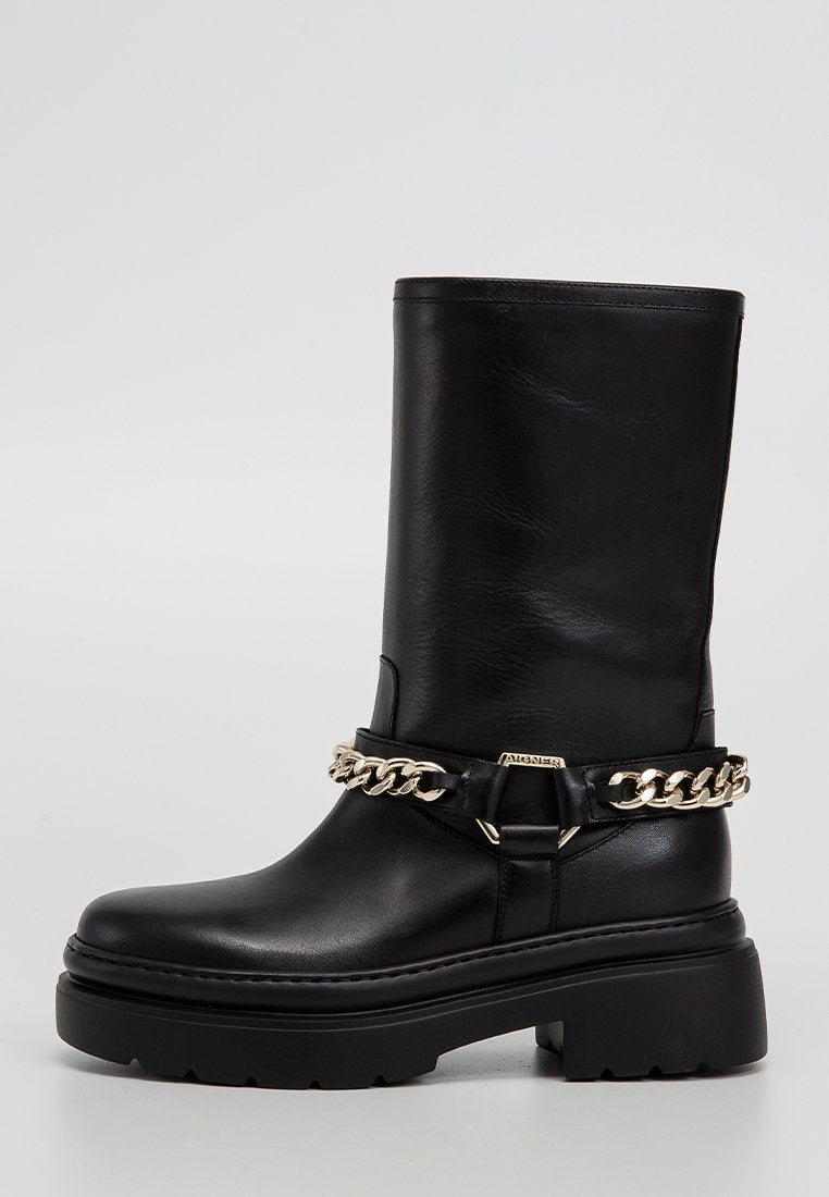 Schwarze Lederstiefelette mit einer klobigen Plateausohle. Verfügt über eine goldene Kettenakzentuierung um den Knöchel und eine glatte Textur.