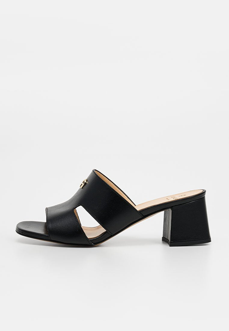 Schwarzer Leder-Open-Toe-Muleschuh mit Blockabsatz und ausgeschnittenen Seiten, mit kleinem goldfarbenem Logo auf dem oberen Riemen.