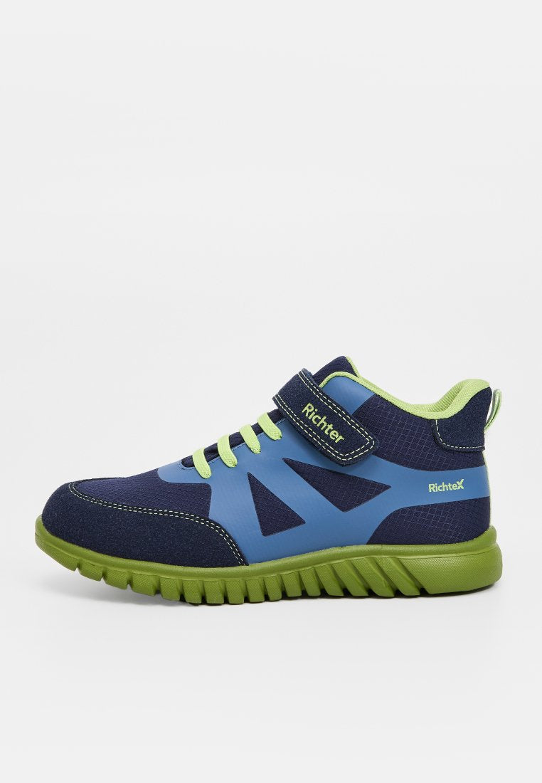 Blauer und grüner Sportschuh mit textilem Obermaterial, Gummisohle, Klettverschluss und geometrischen Ausschnitten zur Belüftung.