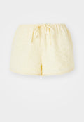 Gelbe Baumwollshorts mit elastischem Bund und Kordelzug. Verfügt über gestickte Blumenmuster und einen gewellten Saum.