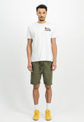 Weißes Baumwoll-T-Shirt mit gesticktem Design, kombiniert mit olivgrünen Shorts. Das Model trägt gelbe Sneakers und weiße Socken.