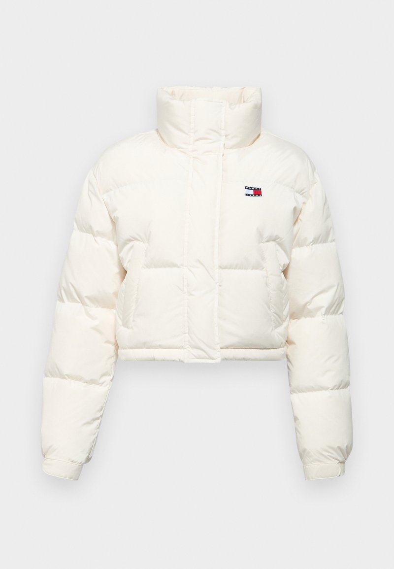 Gekürzte Daunenjacke aus cremefarbenem Stoff mit hohem Kragen, gesteppten Abschnitten und einem kleinen Logodetail auf der Brust. Akzentuierte Bündchen.