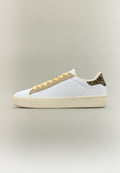 Weißer Sneaker mit niedrigem Schaft, beigefarbenen Schnürsenkeln, hellbrauem Besatz und Leopardenmuster-Detail an der Ferse vor neutralem Hintergrund.