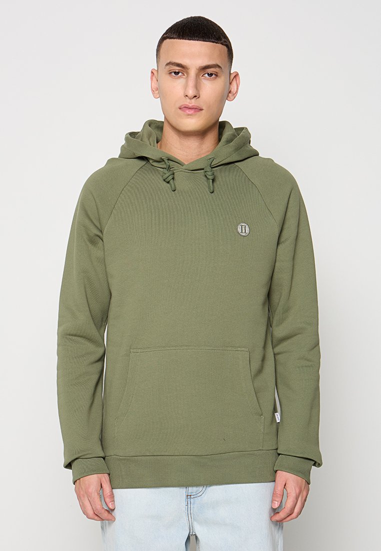 Olivegrüner Hoodie mit strukturiertem Finish, Kordelzugkapuze und Kängurutasche. Mit Raglanärmel und einem kleinen Logoakzent.