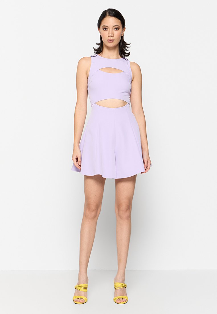 Lilafarbendes Minikleid mit tailliertem Oberteil, Ausschnitten und einem schwingenden Rock. Kombiniert mit gelben Riemchensandalen. Glatte Stofftextur.