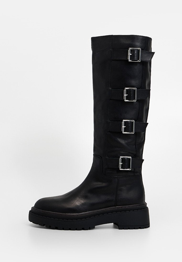 Hoher schwarzer Lederstiefel mit klobiger Sohle und vier verstellbaren silbernen Schnallen an der Außenseite.