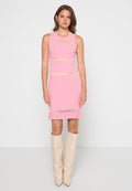 Rosa geripptes Kleid mit horizontalen transparenten Streifen, figurbetontem Schnitt und volantiertem Saum. Kombiniert mit beigen Stiefeln bis zum Knie.